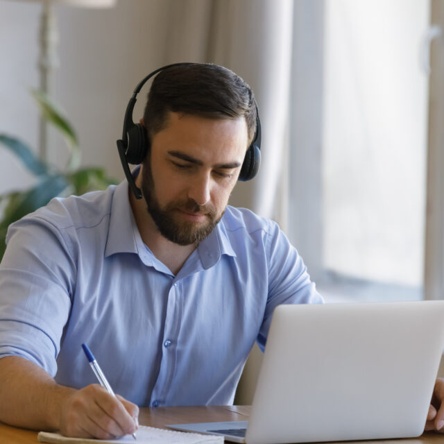 Focused young man studying distantly at home.